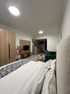 a bedroom with a bed and a living room at Little Loft - The Loftel Ruaka in Nairobi