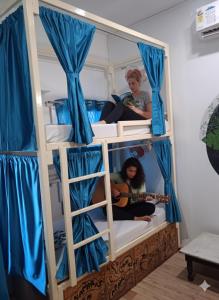 two girls in a bunk bed with a guitar at Kashi Vibes Hostel in Varanasi