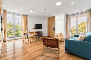 Una sala de estar con un sofá azul y una mesa. en Heřmánek by Mountain ways, en Abertamy