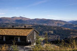 un gran edificio con montañas en el fondo en Mountain Dream, en Vossevangen 5 fotos más