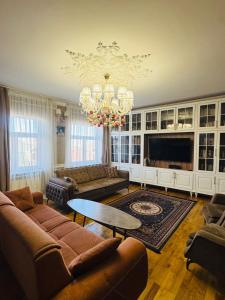 a living room with a couch and a chandelier at Priority Ganja in Ganja