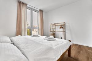 Cama blanca en habitación con ventana grande en Heřmánek by Mountain ways, en Abertamy