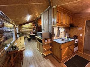 a kitchen with wooden cabinets and a sink in a room at Pousada e Camping do Motochileiro in Urubici
