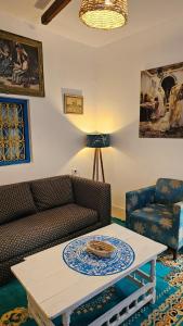 a living room with a couch and a table at Dar Sidi Bou - Free Breakfast - Résidence Oasis Tozeur in Tozeur