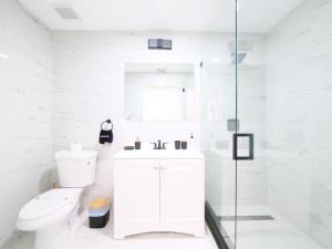 Un baño blanco con inodoro y lavabo. en Dania Beach 4-bedroom house - Pool,Parking,Grill, en Dania Beach 31 fotos más