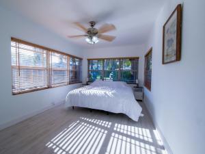 Un dormitorio con una cama y un ventilador de techo. en Dania Beach 4-bedroom house - Pool,Parking,Grill, en Dania Beach