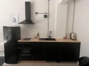a kitchen with a sink and a black refrigerator at Beautiful studio near the station in London