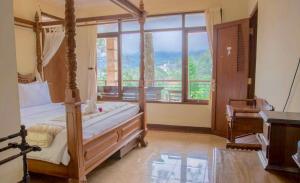 1 dormitorio con cama con dosel y ventana grande en Talita Mountain Resort, en Ciseureuh