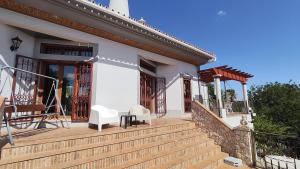 a house with a wooden staircase leading to a porch at Casa do Miradouro in São Brás de Alportel