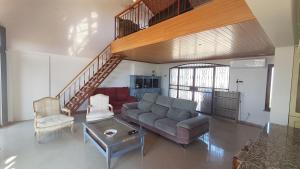 a living room with a couch and a staircase at Casa do Miradouro in São Brás de Alportel