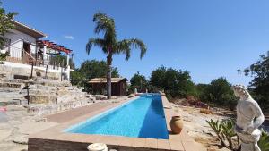 a swimming pool with a statue next to a house at Casa do Miradouro in São Brás de Alportel