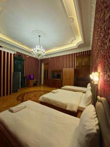 a hotel room with two beds and a chandelier at Hôtel Jeanne d'Arc Central in Baku +12 photos