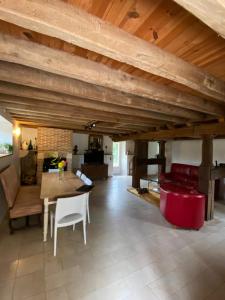 a large living room with a table and red chairs at Le Moulin de la Doltière in Châteauvieux