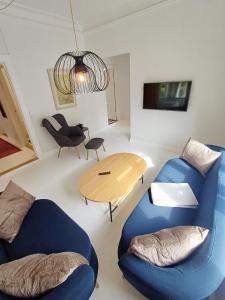 Una sala de estar con dos sillas azules y una mesa. en Exclusive Luxury Apartment in the Heart of Aalborg, en Aalborg