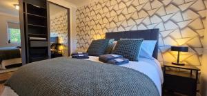 Un dormitorio con una cama grande con almohadas azules. en Malina at The Green, en Glasgow