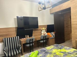 a bedroom with a tv and a table and chairs at Pekini Plaza Onix in Tbilisi City