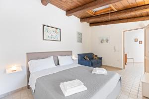 a bedroom with a large bed and a blue chair at Il Fascino Del Borgo in Scano Montiferro