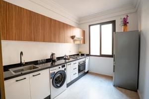 une cuisine avec un réfrigérateur et un lave-vaisselle dans l'établissement œil de la vallée, à Marrakech