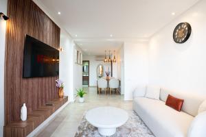 un salon avec un canapé et une télévision sur un mur dans l'établissement œil de la vallée, à Marrakech