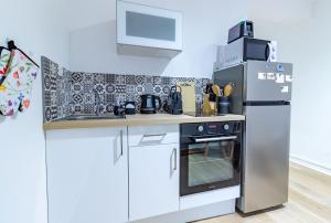 una cocina con estufa y refrigerador en Le Manège - Troyes hypercentre - 1 min Mairie - Wifi 637 Mbits -, en Troyes