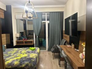 a bedroom with a table and a bed and a dining room at Pekini Plaza Onix in Tbilisi City