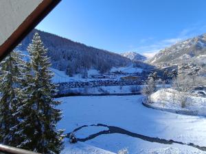 a view of a snow covered valley with a tree at Appartamento panoramico in montagna Alpi Bardonecchia in Bardonecchia