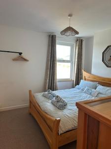 a bedroom with a bed with towels on it at Cumbric Cottage - Cosy Lake District Escape in Lamplugh