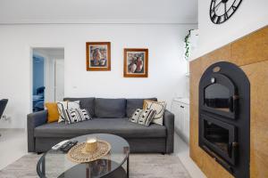 a living room with a couch and a fireplace at CB Living - Cozy condo with patio, Playa Flamenca in Orihuela Costa