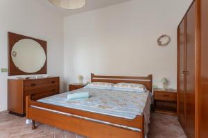 a bedroom with a large bed and a mirror at Villetta Al Mare - S'archittu in S'archittu Cuglieri