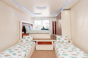 ein kleines Schlafzimmer mit zwei Betten und einem Schreibtisch in der Unterkunft L'étoile de Tanger - Jacuzzi - Proche plage & Corniche - Appartement Chic et Moderne - Jusqu'à 8 personnes - AC, WIFI, IPTV in Tangier