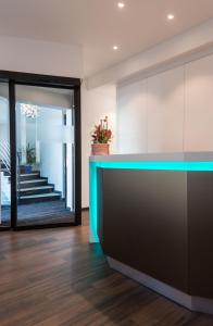 a lobby with a blue counter and a staircase at Rheinterrassen Hotel Café Restaurant in Widdig