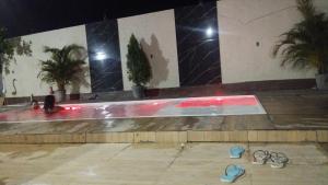 a pair of flip flops in a swimming pool at night at Inn R1 Pousada e Passeios in Barreirinhas