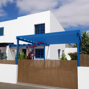 ein weißes Haus mit einem blauen Dach in der Unterkunft VILLA BARRACUDA - "Seaview 3min walk to the beach" in Playa Blanca