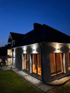 a large white house with a patio at night at Roztoczański Raj in Rogóźno