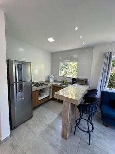 a kitchen with a refrigerator and a table and chairs at Greek House Premium in Arraial do Cabo +13 photos