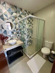 a bathroom with a shower and a toilet and a sink at Greek House Premium in Arraial do Cabo