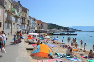 a group of people on a beach in the water at Apartment Sandi in Baška
