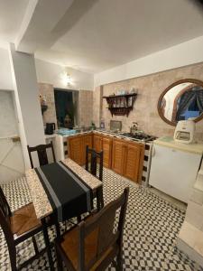 a kitchen with a table and chairs and a refrigerator at Dar fenan Lina in Chefchaouen +14 photos