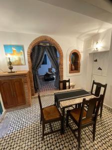 a dining room with a table and chairs and an archway at Dar fenan Lina in Chefchaouen