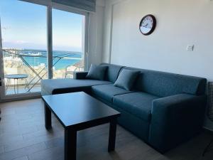 a living room with a couch and a table and a clock at North Residence Sea View Cozy Home in Kyrenia