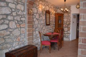 a room with a table and chairs and a stone wall at Apartment Sandi in Baška