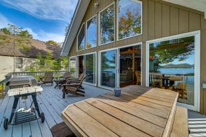 a large deck with a wooden table and benches at Waterfront Lake Pleasant Retreat with Private Dock in Lake Pleasant