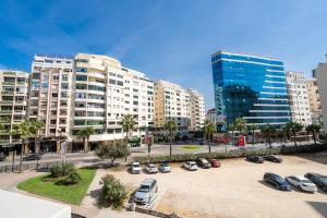 ein Parkplatz mit geparkten Autos in einer Stadt in der Unterkunft L'étoile de Tanger - Jacuzzi - Proche plage & Corniche - Appartement Chic et Moderne - Jusqu'à 8 personnes - AC, WIFI, IPTV in Tangier
