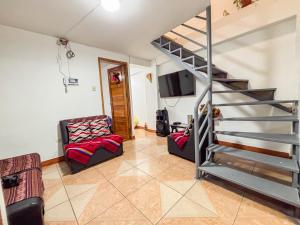 a living room with a spiral staircase and a couch at Los Chullos in Cusco