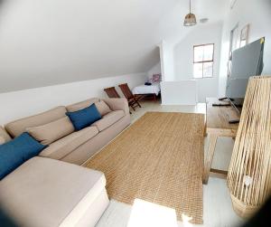 a living room with a couch and a television at 8 Eden Villa in Yzerfontein