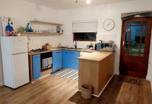 a kitchen with blue cabinets and a white refrigerator at 8 Eden Villa in Yzerfontein