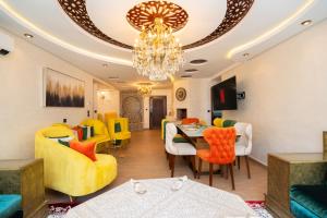 ein Wohnzimmer mit einem Kronleuchter und gelben Stühlen in der Unterkunft L'étoile de Tanger - Jacuzzi - Proche plage & Corniche - Appartement Chic et Moderne - Jusqu'à 8 personnes - AC, WIFI, IPTV in Tangier