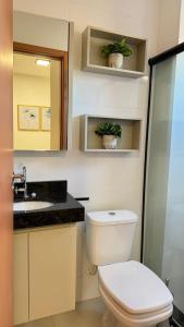 Un baño con inodoro, lavabo y espejo. en 107-4 · Suíte Aconchego Blue prox. UniEvangélica, en Anápolis