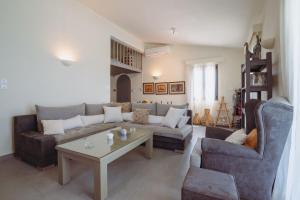 a living room with a couch and a table at Villa Filokalia With Exceptional View - Happy Rentals in Kastro Kyllini