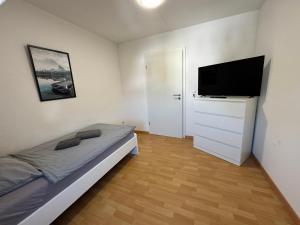 a bedroom with a bed and a flat screen tv at TOP Monteurwohnung, 7 Einzelbetten, Küche, Parkplatz, Nähe Heilbronn I Hyra Living I GEM01 in Gemmingen